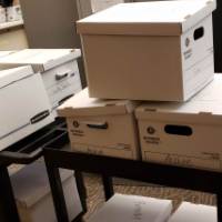 Photo of several filing boxes stacked on carts to move to the basement